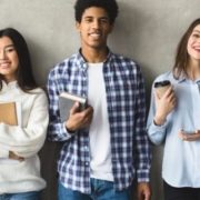 Multiethnic group of university students against college grey wall, panorama