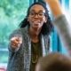 A dedicated black female teacher enthusiastically guiding her students through a lesson, fostering an engaging and inclusive learning environment.