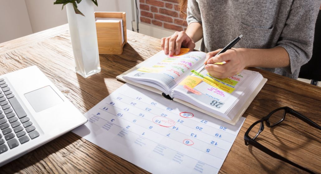 A person reads a textbook at a wooden desk